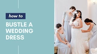 How to Bustle a Wedding Dress • How To Videos [upl. by Drawets]